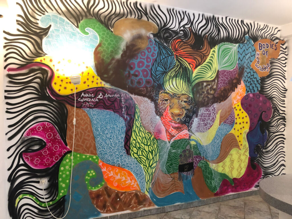 Die Künstler:innen Amoako Boafo und Ani Ganzala gestalteten eine gesamte Wand im Veranstaltungsbereich des Hauses. Ansicht der gesamten Wand